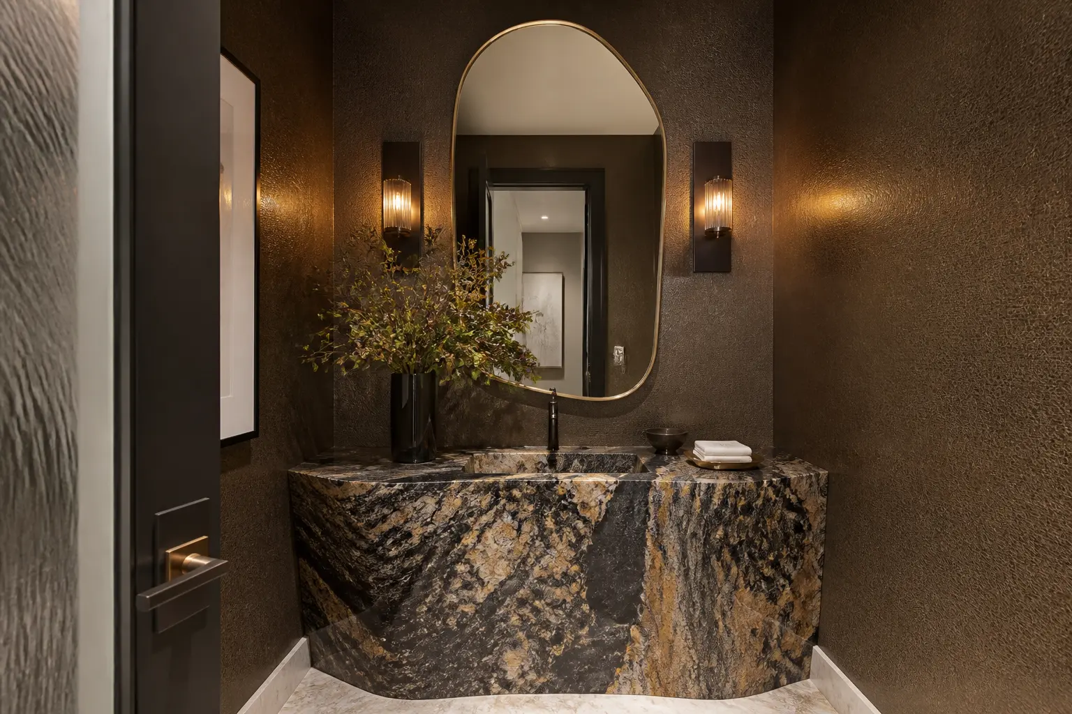Beverly Hills powder room with dramatic stone vanity, textured walls and brass mirror