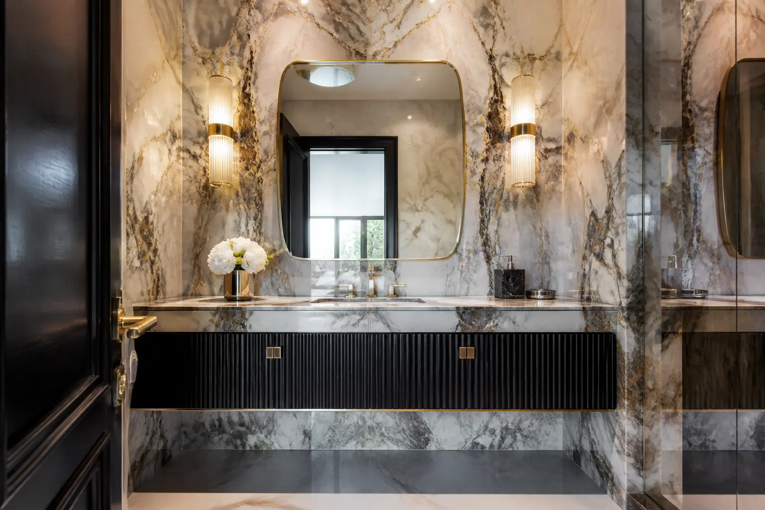 Luxury powder room with veined marble walls, fluted black vanity and brass mirror